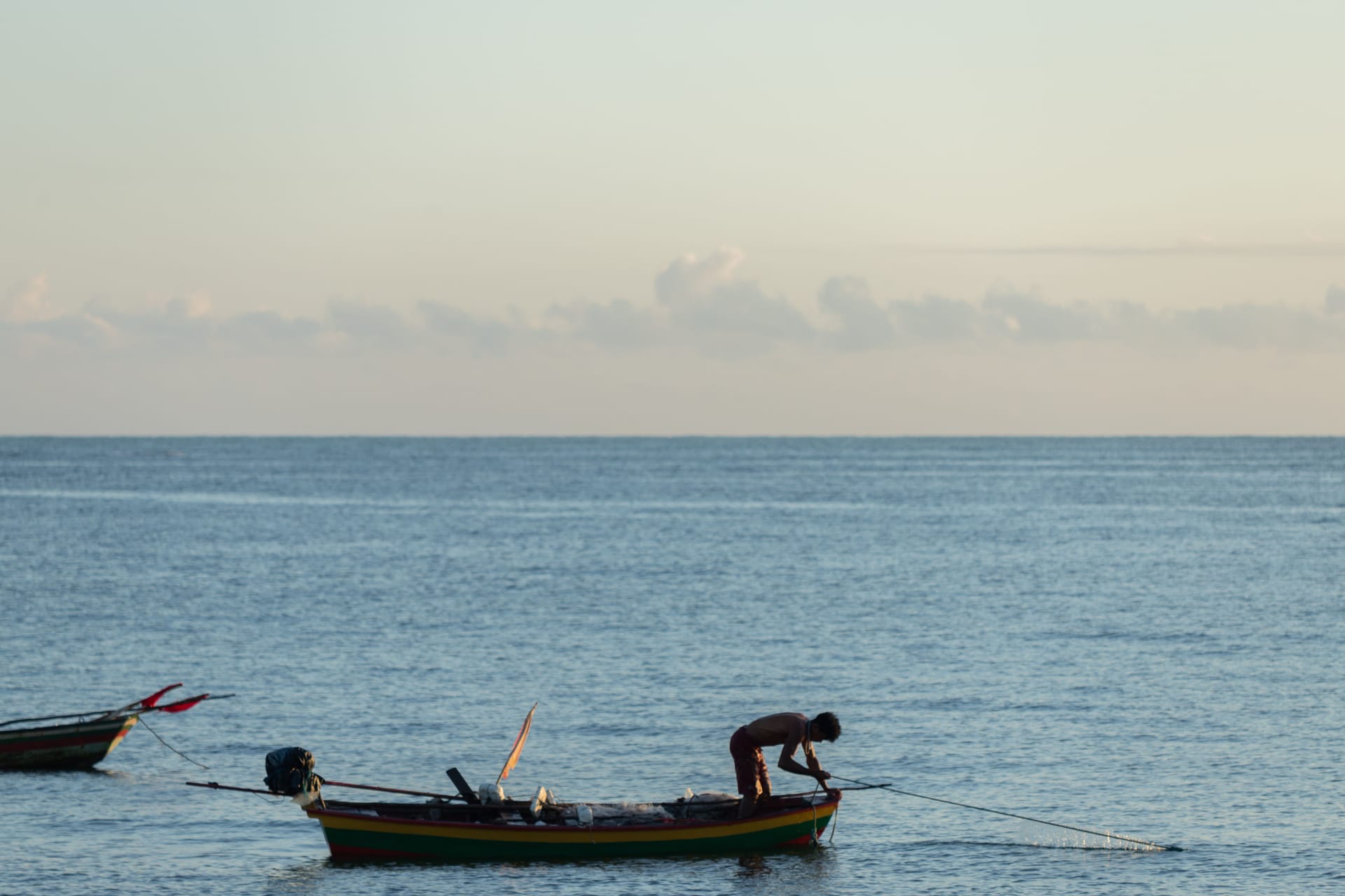 Un lavoratore da remoto al laptop su una veranda fronte mare a Rote, con antenna Starlink accanto e oceano sullo sfondo