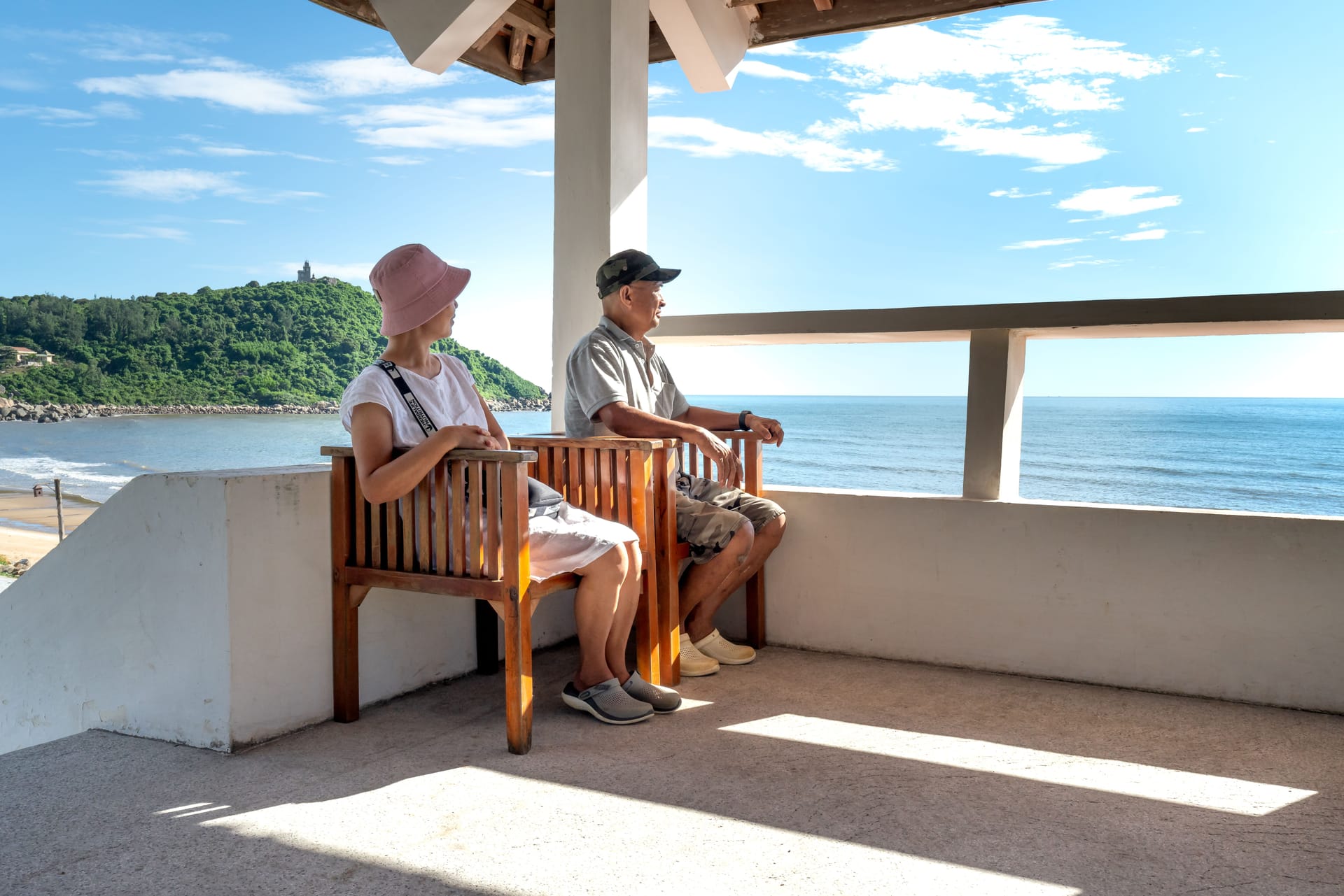 Un pensionato straniero seduto davanti a un warung sulla spiaggia di Rote all'alba, mentre chiacchiera con un abitante del posto