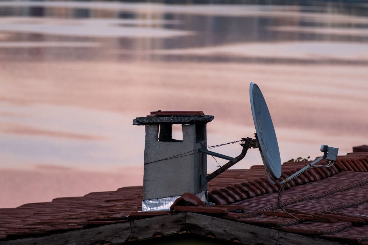 Antenna satellitare Starlink installata accanto a una casa locale a Rote, con smartphone come backup di dati mobili